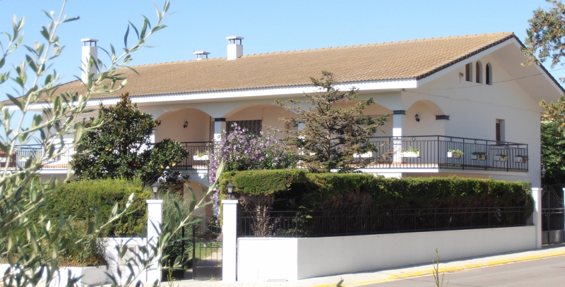 La casa vista desde la calle, entre olivos