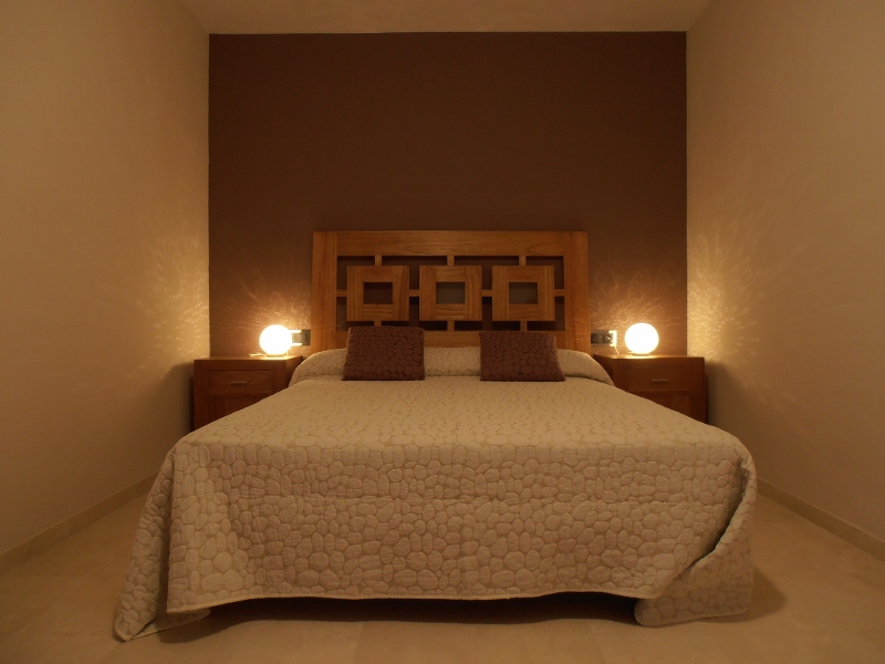 Habitación de matrimonio con cabecero de madera