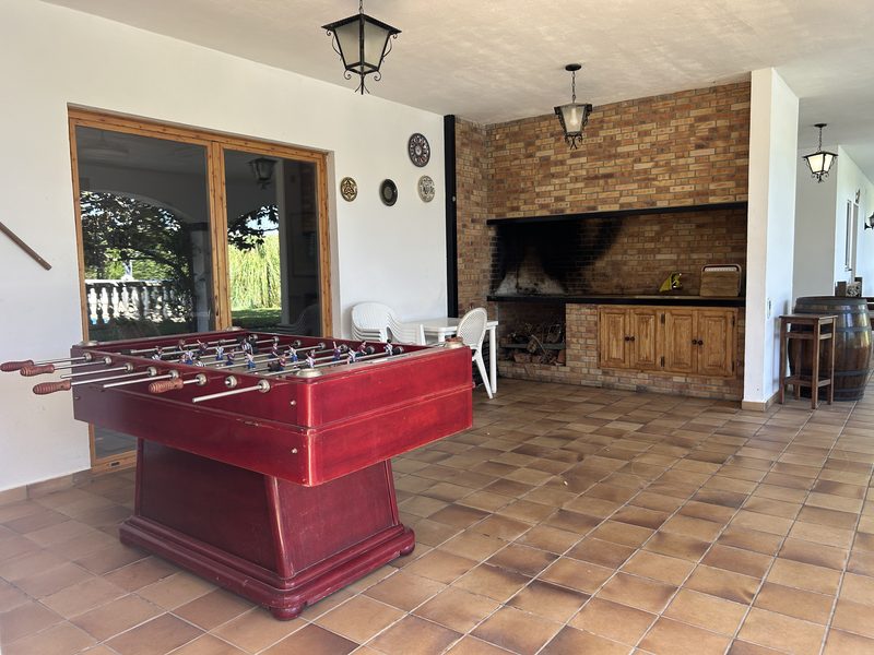 Futbolín junto a la barbacoa de obra del porche